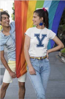 Man and woman pose with LGBTQ flag.  