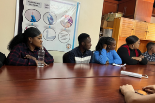 Participants look on in front of table as they learn about the clinic.