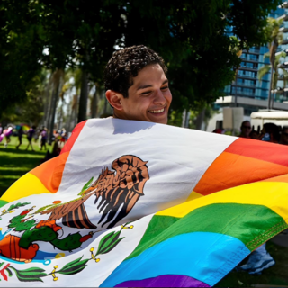 Alejandro spins with a Mexican LGBTQ flag